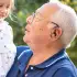 grandad wearing AmpliHear in the garden with his grand daughter